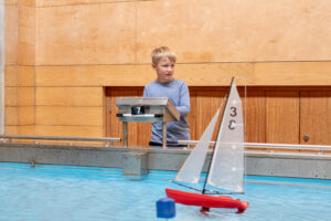 A visitor sailing a boat on the Boat Pool at National Maritime Museum Cornwall A visitor sailing a boat on the Boat Pool at National Maritime Museum Cornwall