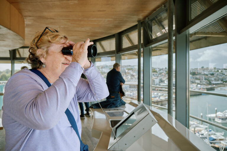 A visitor admiring the view from The Lookout at National Maritime Museum Cornwall A visitor admiring the view from The Lookout at National Maritime Museum Cornwall